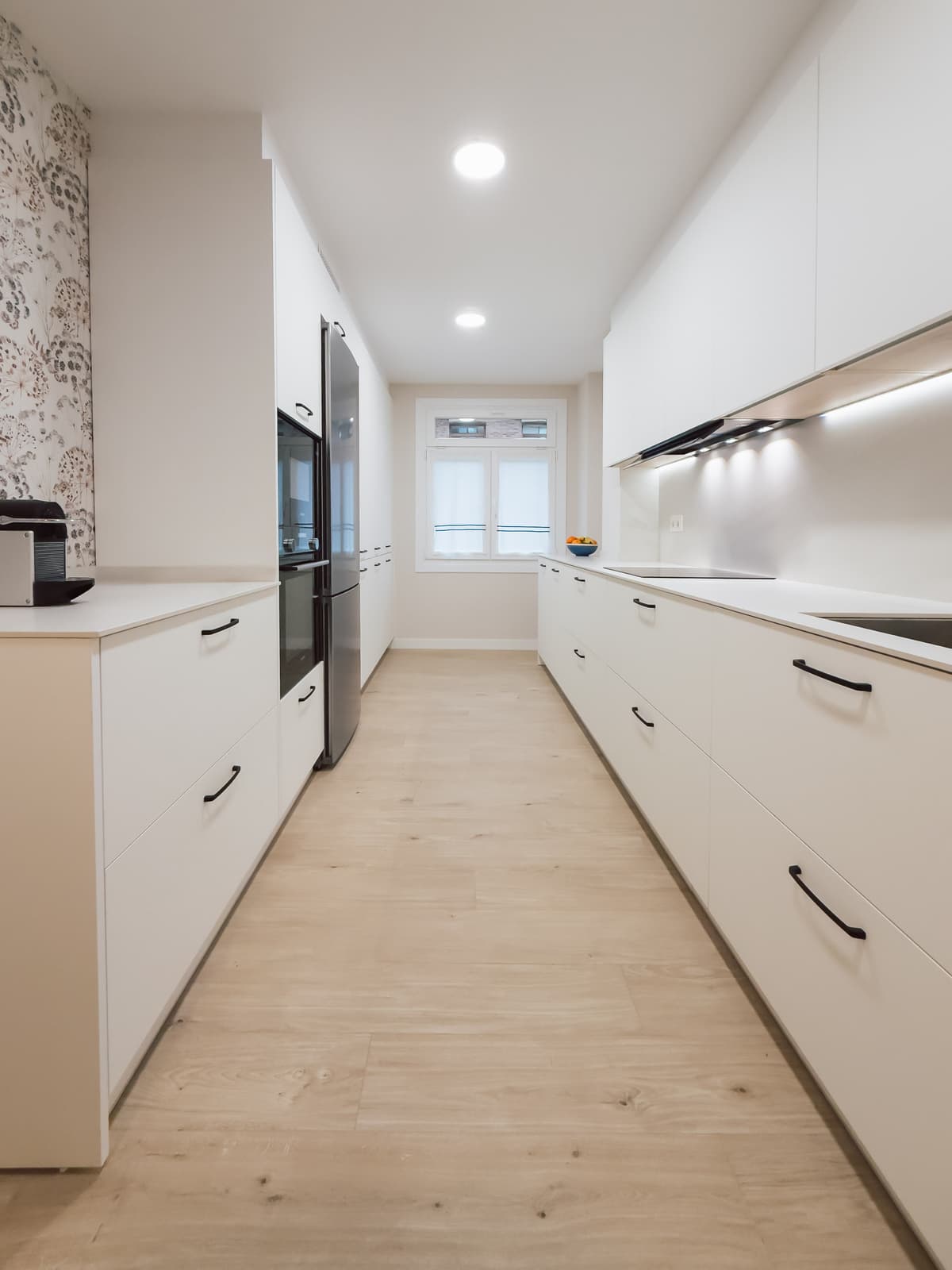 Cocina galley blanca con papel pintado floral · vista 3